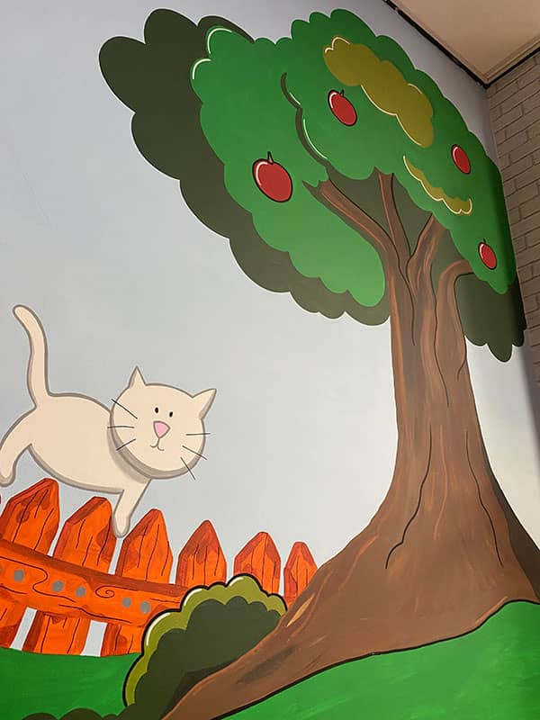 Hand painted mural of cat on children's bedroom wall